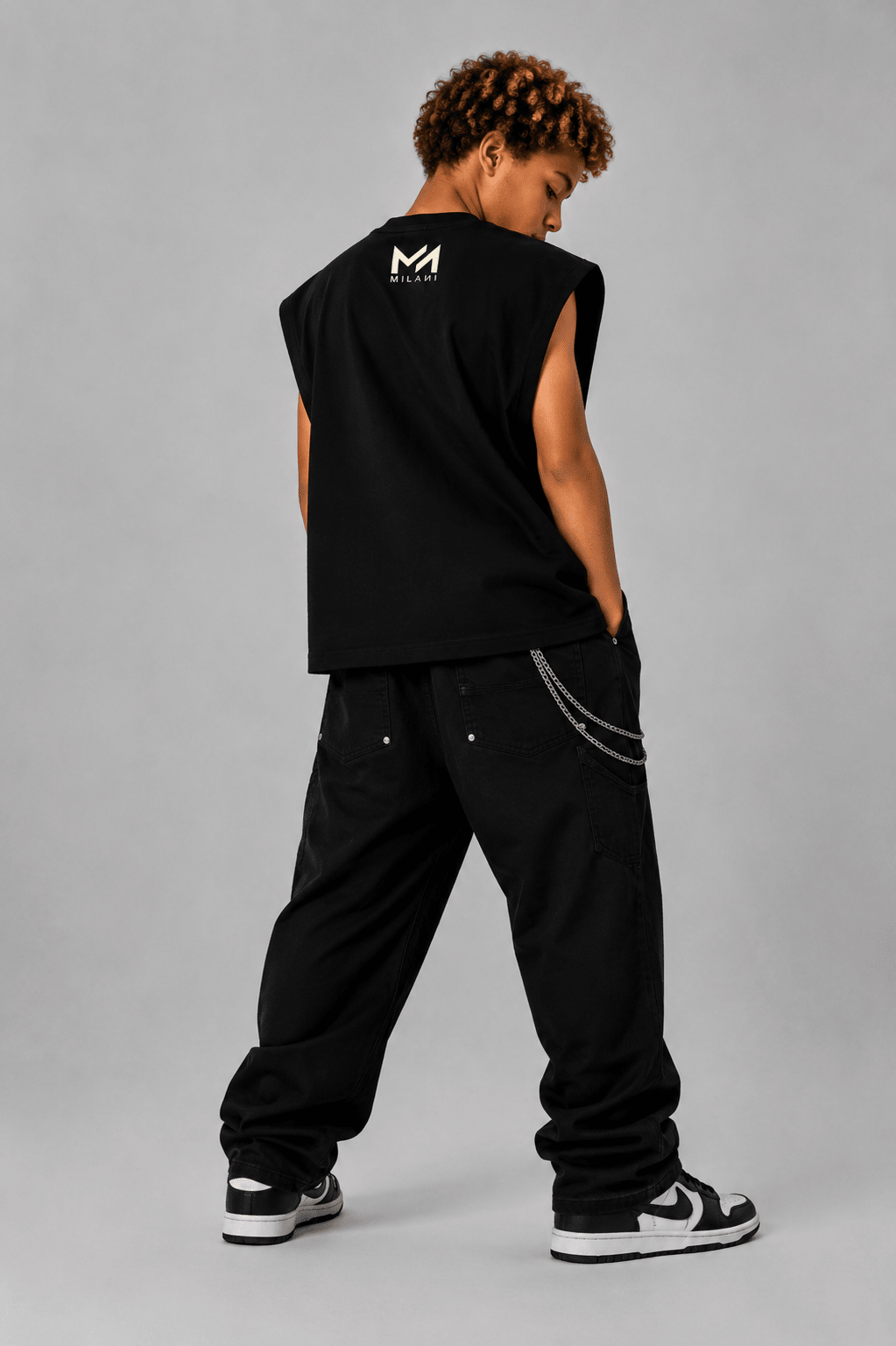MILANI Born for Stardom Heavyweight Sleeveless Tee – Black - MILANI CLOTHINGMILANI Born for Stardom Heavyweight Sleeveless Tee – BlackMILANI CLOTHINGMILANI CLOTHING6-7 yearsPerson wearing a black sleeveless shirt and pants with a logo on the back, standing against a gray background.