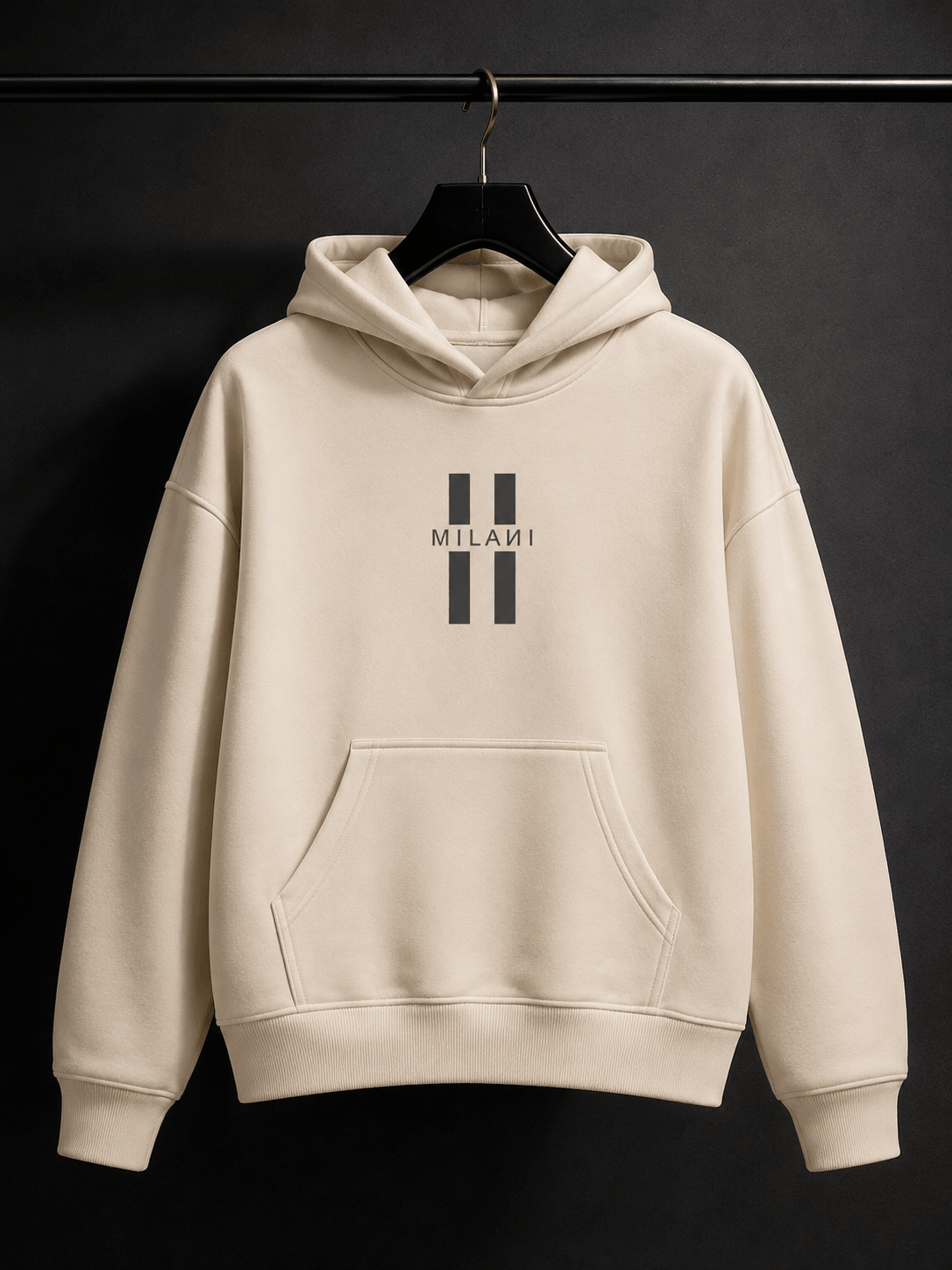 MILANI Untamed Heavyweight Kids Hoodie – Cream - MILANI CLOTHINGMILANI Untamed Heavyweight Kids Hoodie – CreamLoosefit Heavyweight hoodieMILANI CLOTHINGMILANI CLOTHING4-6 YearsA cream-colored pullover hoodie with a black double-stripe logo and the word 'MILANI' printed on the chest, hanging on a black hanger against a dark background.